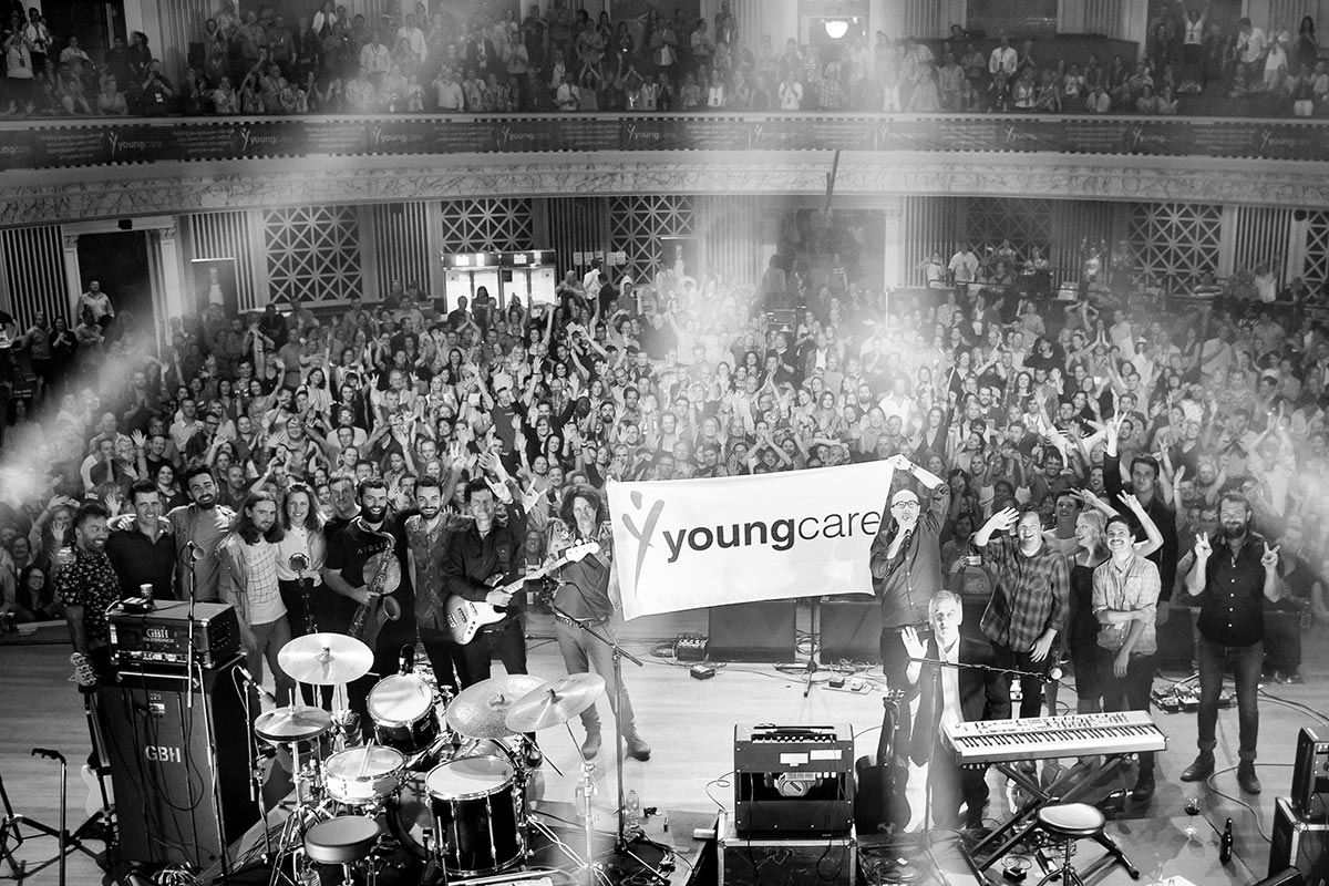 Bands-of-the-Youngcare-Benefit-Concert-holding-a-Youngcare-flag-in-front-of-the-crowd