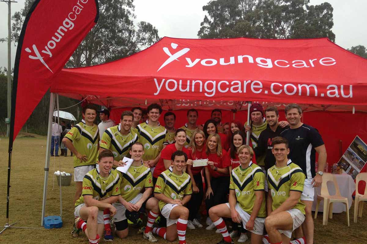 Corporate rugby 10s teams in front of the Youngcare tent