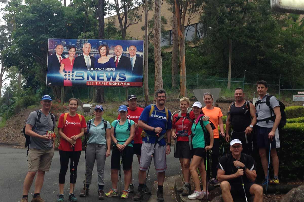 Simpson Desert 2016 trekkers in front of Channel 9 sign at Mt Cooth-tha